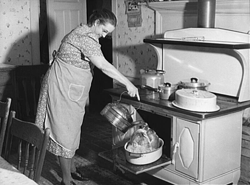 Mrs. T. M. Crouch, of Ledyard. Connecticut pouring some water over her twenty-pound turkey on Thanksgiving Day