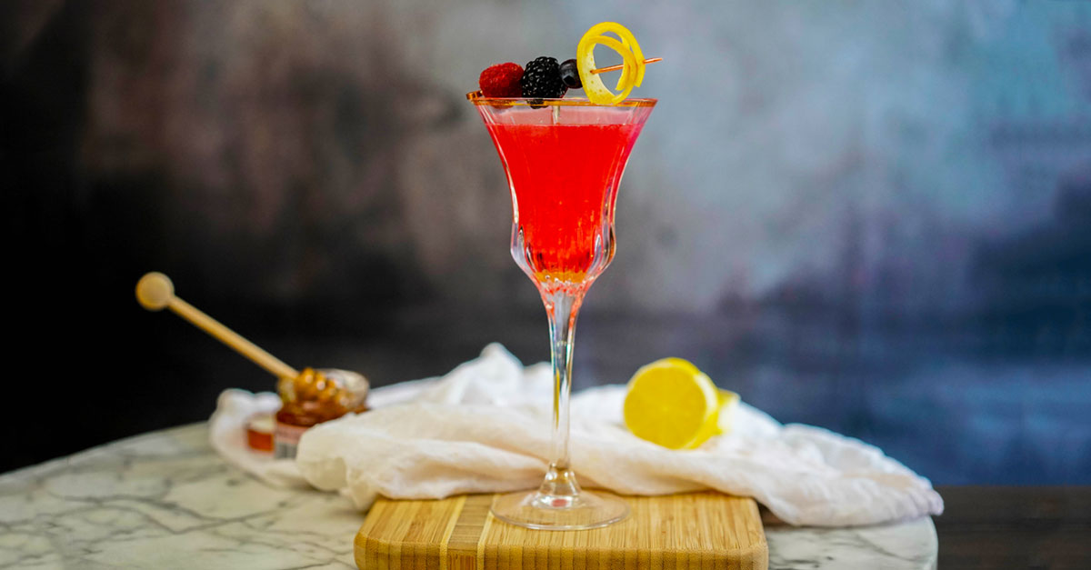 This twist on the classic Bee's Knees gin cocktail incorporates a mix of berries. It is easy to make at home with whatever fruit you have on hand. Learn how to make it with this recipe!