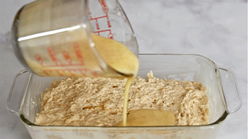 How to Make Beer Bread: Pour the melted butter mixture in an even layer over the dough.