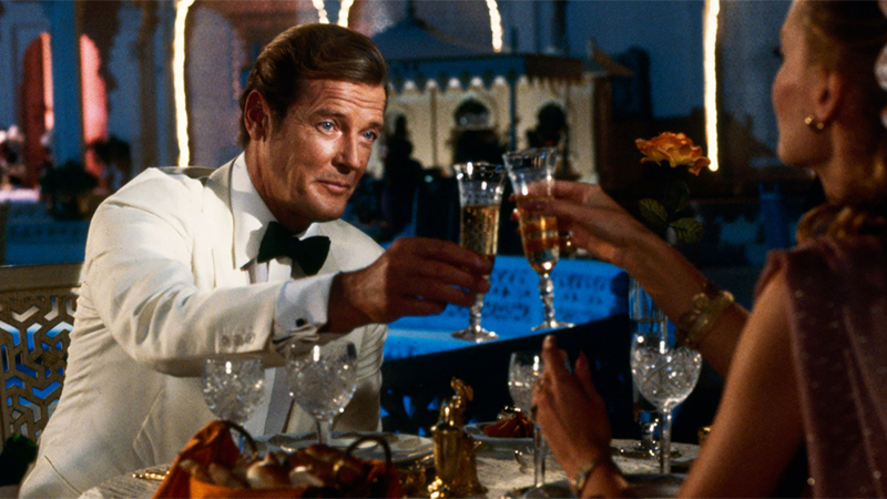 James Bond toasting with a glass of champagne in hand. 