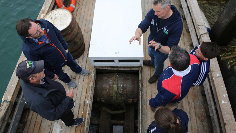 Carl O'Grady stands on The Dolphin, a 36-foot wooden-hulled vessel built in 1969, that unfortunately sank a few decades later, but was resurrected in 2015 to age whiskey.