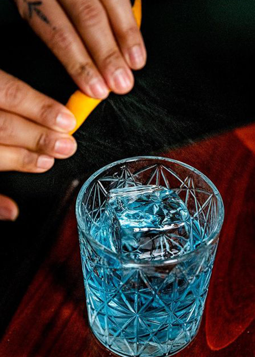 The signature blue Negroni cocktail from NYC's Temple Bar is an example of a cocktail's color impacting the emotional impulse behind ordering a drink.