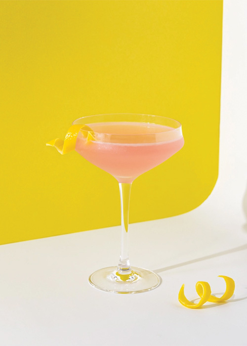 The Cosmopolitan is a pink cocktail with a lemon twist garnish