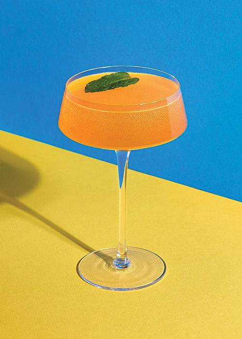 The Old Cuban is an orange-hued drink with a mint garnish