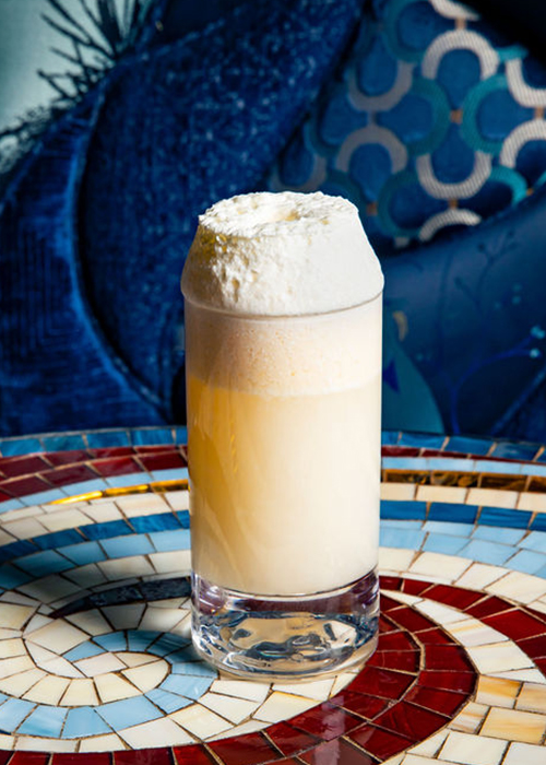 Shinji's Gin Fizz features Fords GIn, hojicha vanilla syrup, egg white powder, and water seasoned with the flavor of citrus marigold flowers. 