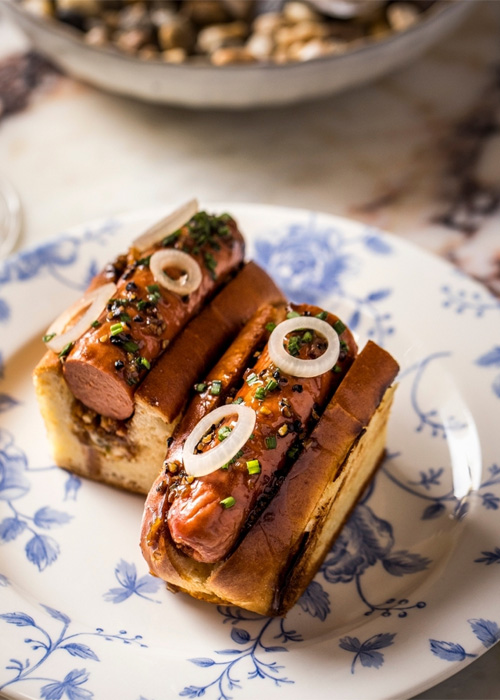 At The Portrait Bar in the Fifth Avenue Hotel, there is a "Hot Dog Au Poivre" on the baar food menu. 